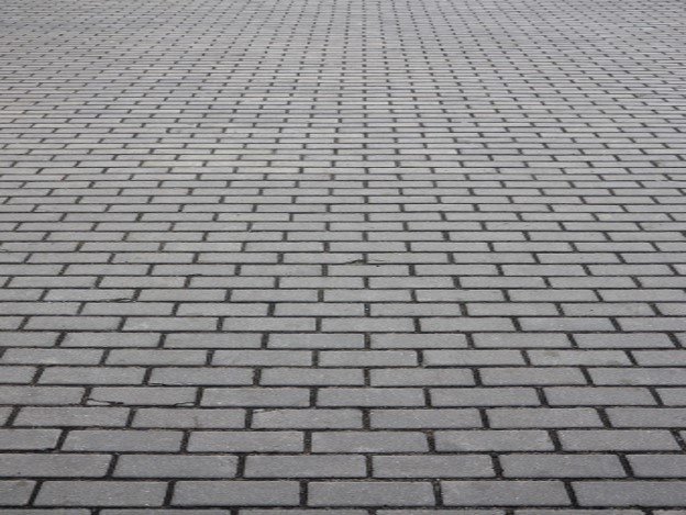 Gray brick paver driveway installed in a running bond pattern for residential property in Beachwood, OH