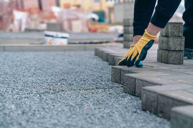 Driveway installation with pavers being placed on a gravel base for a residential property in Chagrin Falls, OH