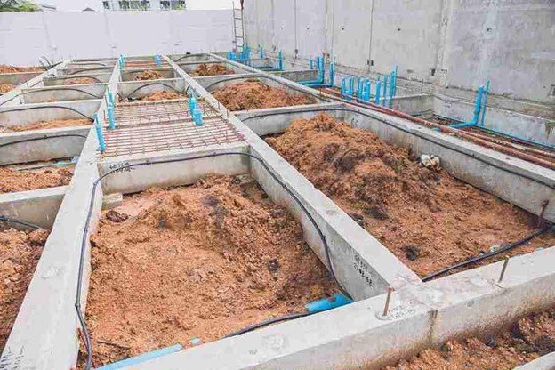Concrete foundation installation with footing layout and plumbing lines prepared for residential build in Beachwood, OH