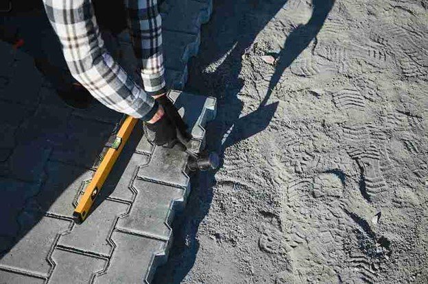 Stamped concrete installation with worker shaping and finishing textured surface in Chagrin Falls, OH