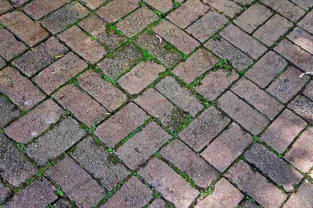 Uneven patio surface with shifting pavers and gaps before concrete patio replacement in Chagrin Falls, OH